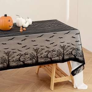 Black lace Halloween tablecloth with bat and tree silhouette on a long wooden table