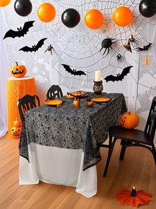Close-up of black lace spider web tablecloth with fine mesh texture and spider pattern