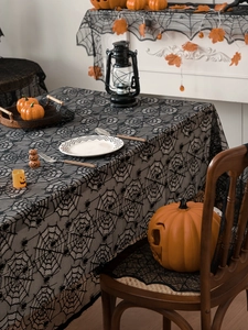 Detail of black lace spiderweb tablecloth used as decorative mantel and chair covers