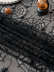 Detail of Halloween black lace tablecloth featuring intricate spider and web patterns