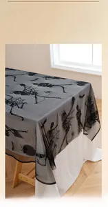 Detail of Halloween black lace tablecloth featuring intricate skull and spider web patterns