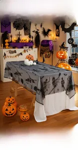 Close-up of black lace Halloween tablecloth with detailed skull and spider web patterns