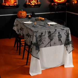 Halloween black lace tablecloth with spider web and skull motifs on a spooky dinner table