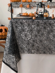 Close-up of Halloween black lace tablecloth featuring intricate spider web patterns