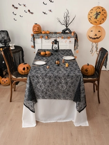 Detailed view of black lace spider web tablecloth and chair covers for Halloween decor