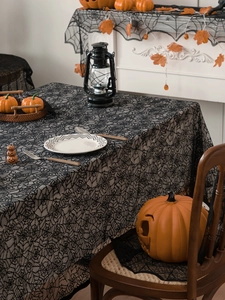 Detailed view of Halloween black lace tablecloth with intricate spider web pattern design