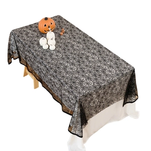 Black lace spider web tablecloth for Halloween decor with detailed spooky mesh patterns