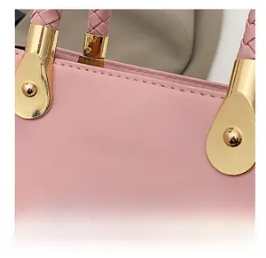 Details des rosa geflochtenen Griffs und der goldenen Beschläge der Umhängetasche