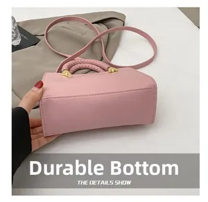 Detailansicht der rosa geflochtenen Handtasche mit verschleißfestem Boden und Golddekor