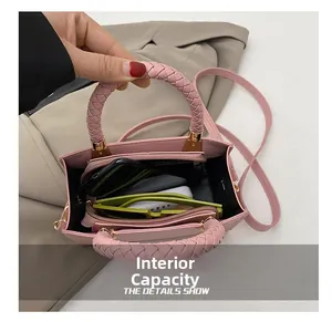 Detailansicht der rosa Handtasche mit geflochtenem Griff und geräumigem Innenfach für Essentials