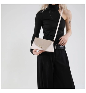 Détail du sac bandoulière blanc cassé avec rabat tissé sur un mannequin en noir