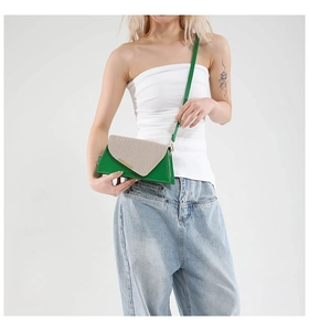 Détail du sac bandoulière en cuir vert et tissu tissé avec garniture en métal et couture