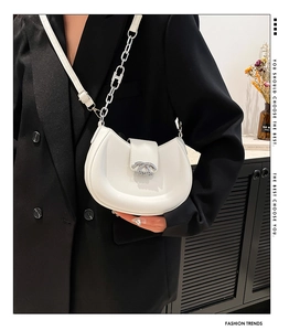 Details der weißen Halbmond-Tasche mit silberner Kette und Logo-Schnalle aus Metall