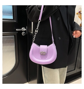 Lila Halbmondtasche mit silberner Hardware an Model in schwarzem Blazer gezeigt