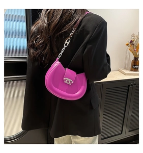 Detailansicht der lila Halbmond-Ledertasche mit silberner Kette an der Schulter des Models