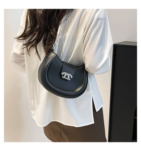 Minimalistische schwarze Halbmond-Tasche mit Silberkette getragen von einem Model