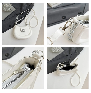 Detail der weißen Halbmond-Tasche mit silberner Kette und Logo-Metallschnalle