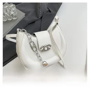 Detail der weißen Halbmondtasche mit silberner Schnalle und dekorativer H-Metallkette