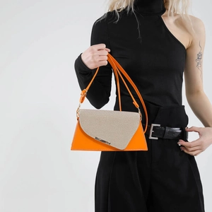 Sac bandoulière géométrique orange et beige à la mode porté par un mannequin