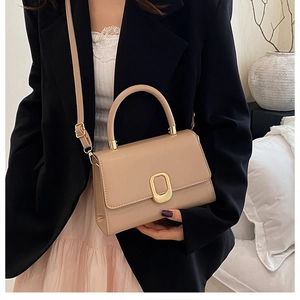 Gros plan d'un petit sac carré en cuir PU beige avec boucle dorée et bandoulière fine