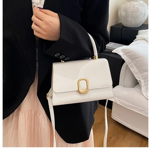Détail du sac à main en cuir blanc avec boucle en métal doré et poignée supérieure