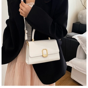 Détail du petit sac blanc élégant avec boucle dorée et bandoulière en cuir souple
