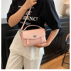Bolso de mensajero rosa minimalista con cierre giratorio usado por modelo