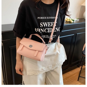Detalle de bolso bandolera de cuero PU rosa con cierre plateado y correas en una modelo