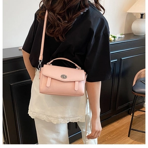 Bolso bandolera de cuero rosa pálido con asa y cierre de giro usado por modelo