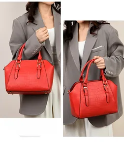 Detail of red crocodile texture tote with elegant golden hardware and top handle