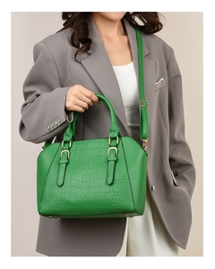 Close-up of green crocodile embossed tote bag with gold buckles and adjustable shoulder strap