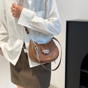 Braune Halbmond-Tasche aus Leder mit Silberkette an einem Model präsentiert
