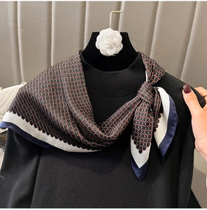 Detail of silk scarf with red and black chain pattern paired with black knit sweater