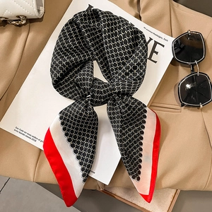 Silk feel neck scarf with black chain pattern and red border on beige blazer backdrop
