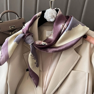 Elegant purple and beige printed silk scarf tied on a suit lapel with camellia decor