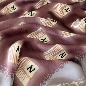 Macro shot of silk fabric featuring geometric patterns and N letter prints with soft folds
