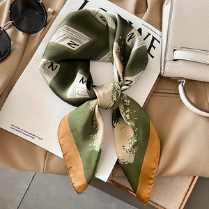 Detail of silk square scarf with letter N pattern, deep green and beige patchwork design