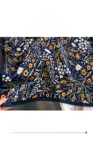 Gros plan d'un foulard en soie avec motif floral vintage et bordures finement roulées