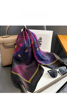 Close-up of silk square scarf featuring leopard and paisley print on a luxury bag