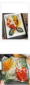 Detailed view of luxury silk scarf with vintage floral patterns and green hand-rolled edges
