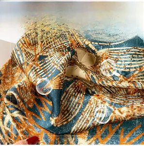 Detailed texture of blue and orange silk scarf featuring tropical palm leaf patterns