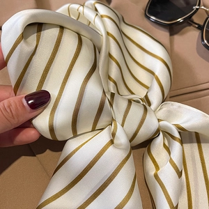Close-up of elegant striped silk scarf with smooth satin texture and diagonal pattern