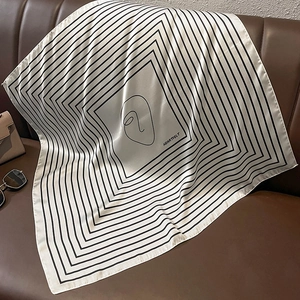 Detail of square silk scarf with minimalist line art on leather background