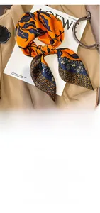 Dettaglio del foulard in seta vintage 70x70cm su un blazer con accessori di lusso