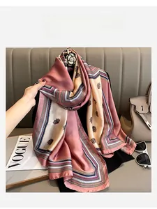 Detailed drape of pink and purple paisley silk scarf hanging on a hanger with lifestyle props
