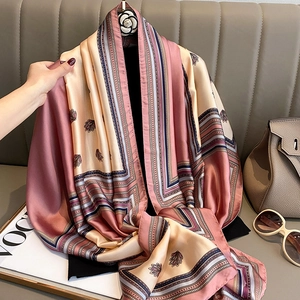 Elegant paisley print silk scarf in soft pink and beige with geometric borders