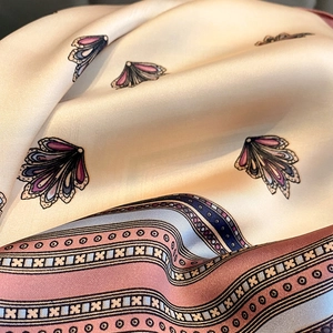 Elegant silk scarf with pink shell patterns and colorful striped edges in creamy white