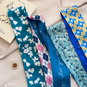 Détail de quatre écharpes en soie imprimées assorties sur un blazer beige élégant