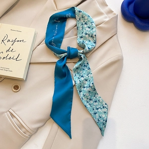 Élégant foulard étroit en soie bleu marine à fleurs sur un blazer beige chic