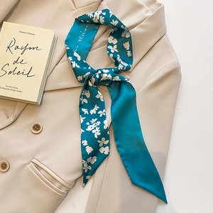 Élégant foulard en soie bleu sarcelle à fleurs sur un blazer pour un style minimaliste